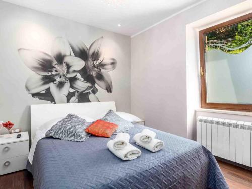 - une chambre avec un lit, des serviettes et des fleurs dans l'établissement Srok Apartments with pool, à Kastav