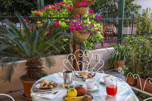 a table with food on it with flowers and plants at B&B Hotel Costa Azzurra in Spotorno