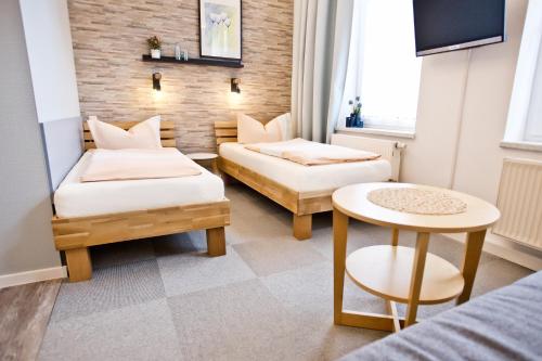 a small room with two beds and a table at Pension Nord in Dessau