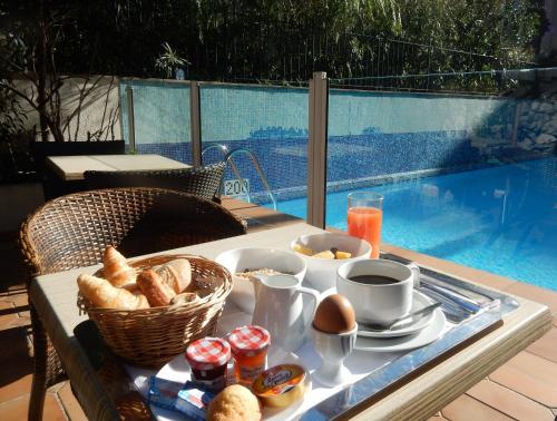 un vassoio di prodotti per la colazione su un tavolo accanto alla piscina di Amarante Cannes a Cannes