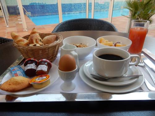 
a table topped with a tray of food and a cup of coffee at Amarante Cannes in Cannes
