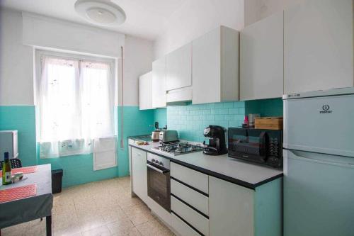 uma cozinha com armários brancos e um forno com placa de fogão em Residenza Franca Vista panoramica em La Spezia