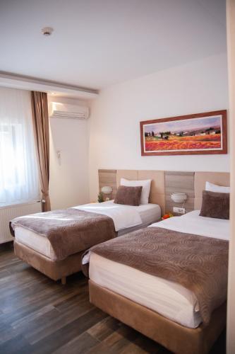 a hotel room with two beds and a painting on the wall at Tourist Resort Ribarsko Ostrvo in Novi Sad
