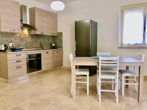 a kitchen with a table and chairs and a refrigerator at Appartamento Iris in San Vincenzo