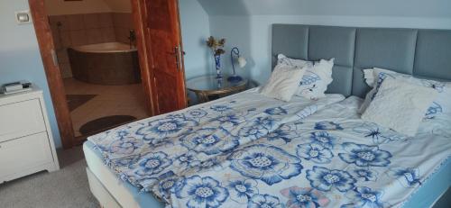 a bed with a blue and white comforter and pillows at Słoneczne apartamenty in Sobótka