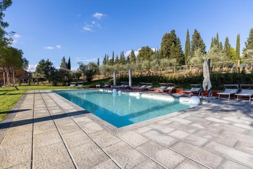 una piscina con sillas y sombrillas en un patio en Agriturismo Poggio Nardini en San Donato a Livizzano