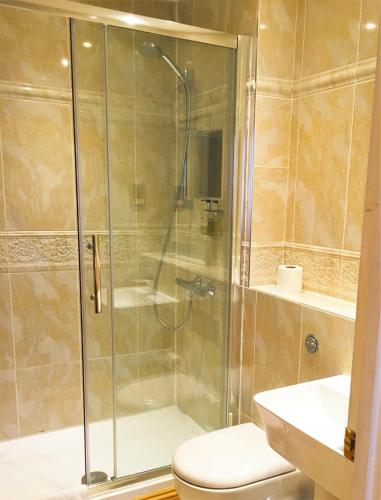 a bathroom with a shower with a toilet and a sink at Hyde Park Radnor Hotel B&B in London