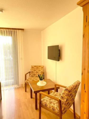 a living room with a table and chairs and a tv at Gasthaus Dernedde in Osterode