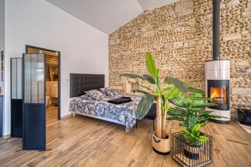 a bedroom with a bed and a brick wall at Le Vieux Platane in Malissard
