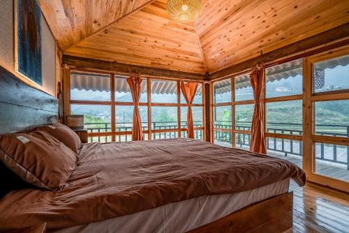 a bedroom with a bed in a room with windows at Deja Vu Sapa Homestay in Sapa