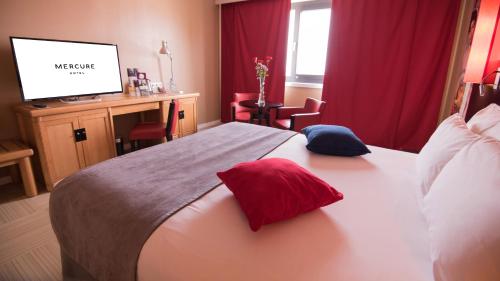 a hotel room with a bed with two pillows on it at Hotel Mercure Alger Aéroport in Dar el Beïda