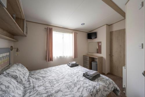 a bedroom with a bed and a window at Hallcroft Fishery And Holiday Park in Retford
