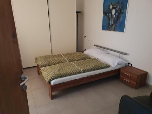 a small bedroom with a bed and a night stand at Villa Monica in Luino