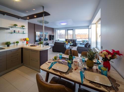a kitchen and a living room with a table and chairs at Skyhouse Riga Lux Penthouse & SPA in Rīga