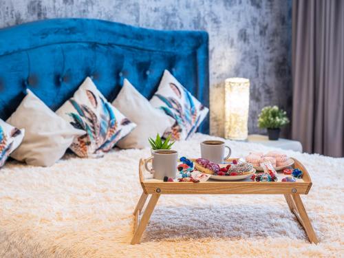 a tray of food on a table on a bed at Skyhouse Riga Lux Penthouse & SPA in Rīga