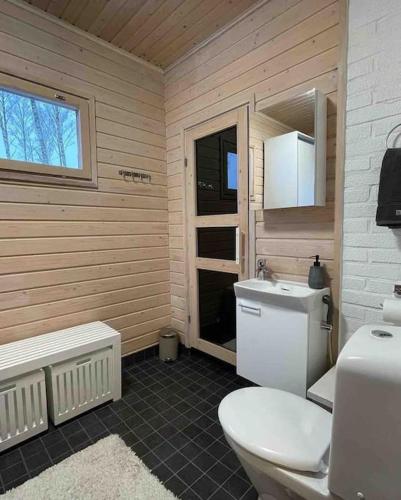 a bathroom with a toilet and a sink at Villa Lyxfällan in Kemionsaari