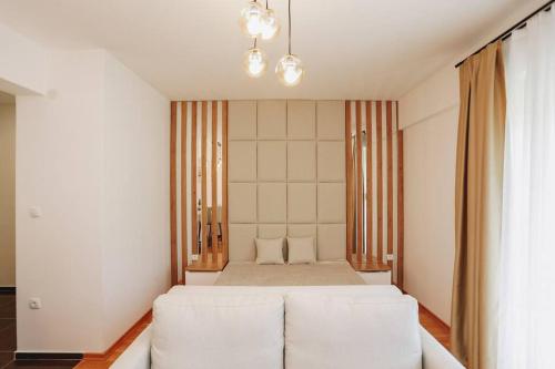 een slaapkamer met een wit bed en een witte bank bij Status-M Apartments 135 in Becici