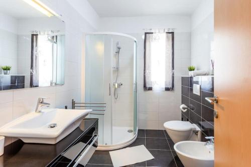 een badkamer met een wastafel, een douche en een toilet bij Apartments Punta Premantura in Premantura