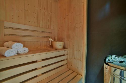 a sauna with towels and a bucket on a shelf at Holiday resort, Grzybowo in Grzybowo