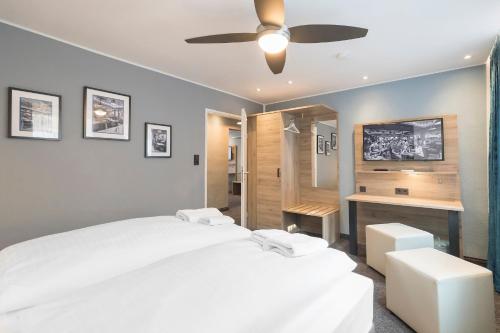a bedroom with two beds and a ceiling fan at Riverview Apartments by dasPaul in Nürnberg