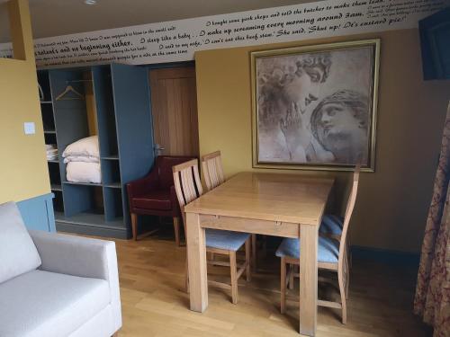 um quarto com uma mesa e cadeiras e uma cama em Star Inn em Stroud