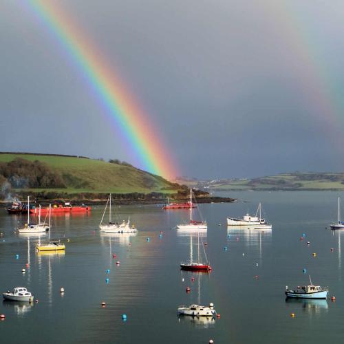 a rainbow over a large body of water with boats at Headland View. Luxury. Harbour-Front. With Parking in Falmouth
