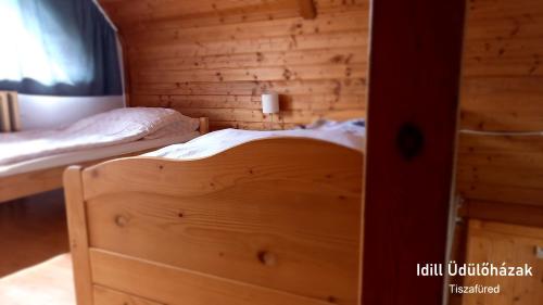 a bedroom with two beds in a wooden cabin at Idill Üdülőház in Tiszafüred