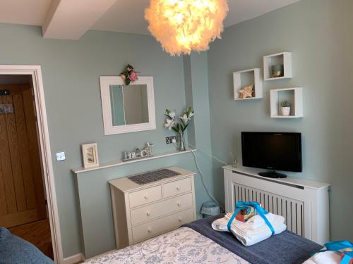 a bedroom with a bed with a television and a dresser at Headland View. Luxury. Harbour-Front. With Parking in Falmouth