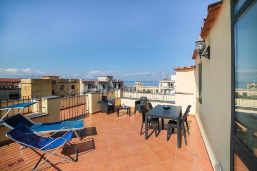 a balcony with a table and chairs on a building at Flowers apartments & rooms in Meta