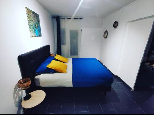 Schlafzimmer mit einem Bett mit blauen und gelben Kissen in der Unterkunft Suite Perla - Balnéo et Sauna in Le Mée-sur-Seine