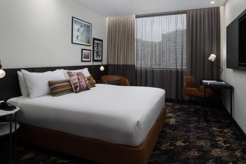 a hotel room with a bed and a television at Rydges Fortitude Valley in Brisbane