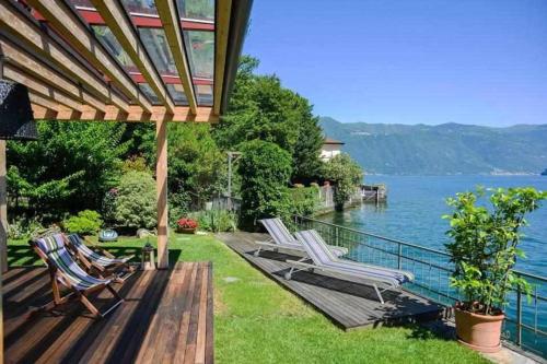 Brienno的住宿－Villa delle Edere，一个带椅子的甲板,享有水景