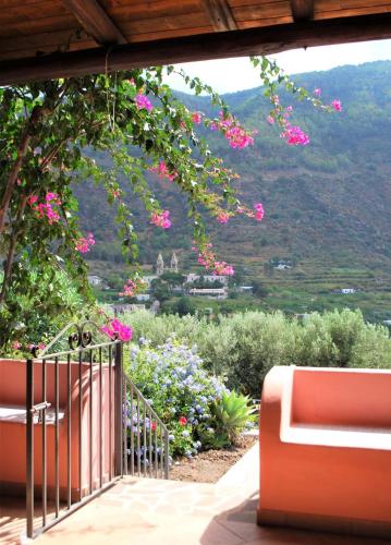 a garden with pink flowers and a fence with a view at Casa I 10 Puleri - Ampio e fresco terrazzo panoramico in Leni