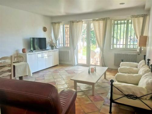 een woonkamer met een bank en een tafel bij Un brin de paille in Cagnes-sur-Mer