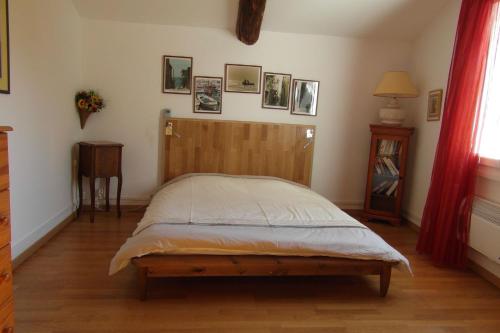 une chambre avec un lit avec une tête de lit en bois dans l'établissement Les Valérianes, à Sablet