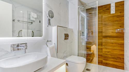 a white bathroom with a sink and a toilet at Quinta do Lago Country Club in Quinta do Lago