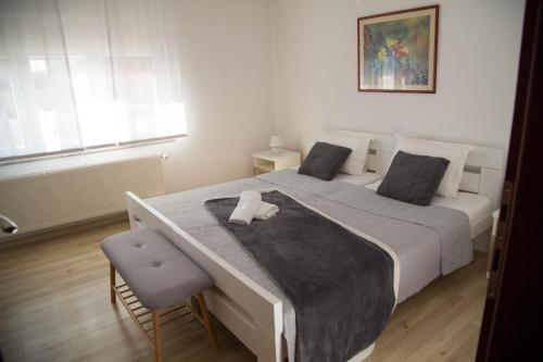 Un dormitorio con una cama grande y una silla. en Apartmani Baotić Županja, en Županja