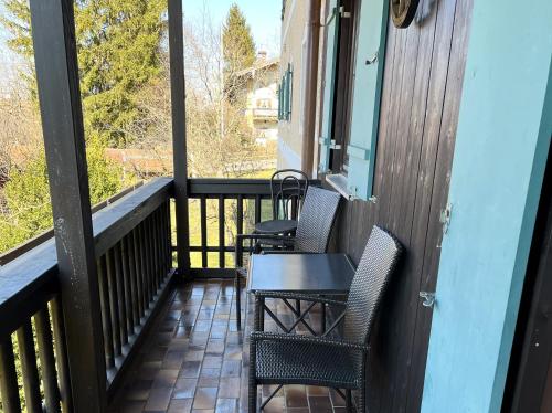 a balcony with two chairs and a table on it at Ferienwohnung Samerhof Langenscheidt in Aschau im Chiemgau