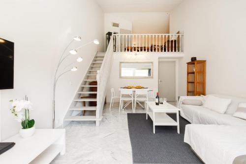 - un salon blanc avec un canapé blanc et un escalier dans l'établissement Nomad YourHostHelper, à Cannes