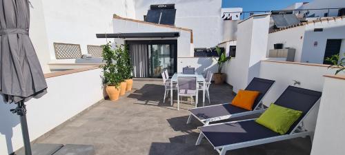 balkon z krzesłami i stołem na budynku w obiekcie Atico en Puerta Osario w Sewilli