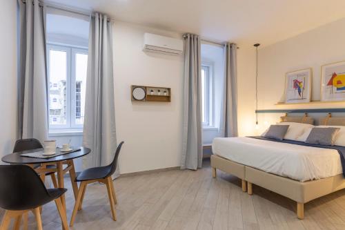 a bedroom with a bed and a table and chairs at Cool and stylish city apartment - WiFi in Trieste