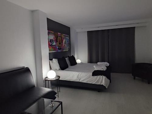 a hotel room with a bed, desk and a television at Urban Spaces Ibiza in Ibiza Town
