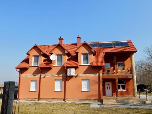 ein Haus mit Sonnenkollektoren auf dem Dach in der Unterkunft Csetáj Vendégház in Hajós