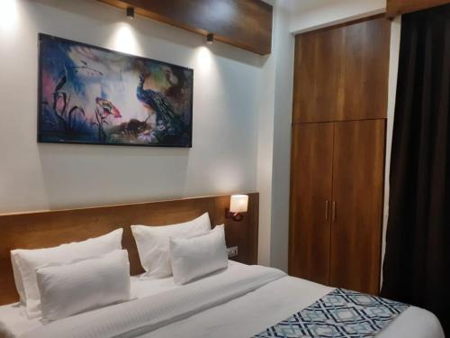 a bedroom with a bed and a painting on the wall at The Govindam Resort in Vrindāvan