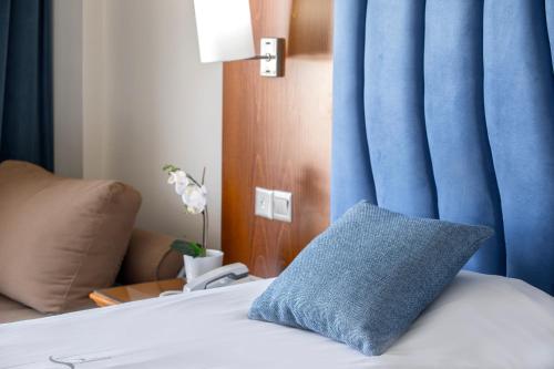 a bed with a blue curtain and a blue pillow on it at Anastasia Waterpark Beach Resort in Protaras