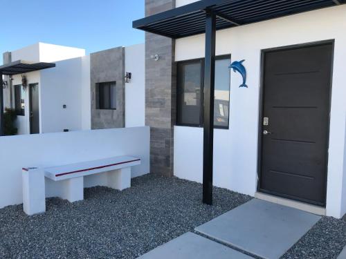 a white building with a bench next to a door at DOLPHIN Maeva Residencial in Puerto Peñasco