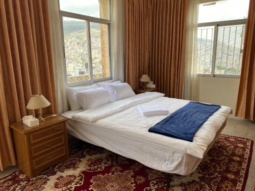 a bedroom with a large bed with a large window at Hayat Guest House in Nablus