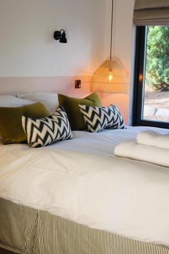 a bed with pillows on it with a window at The Boat Inn in Aboyne