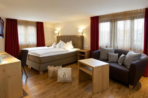 a hotel room with a bed and a couch at Hotel Hirsch in Oberstaufen