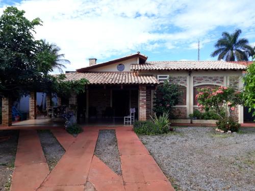 ein Haus mit einem Kacheldach und einer Terrasse in der Unterkunft Casa das Flores in Chapada dos Guimarães